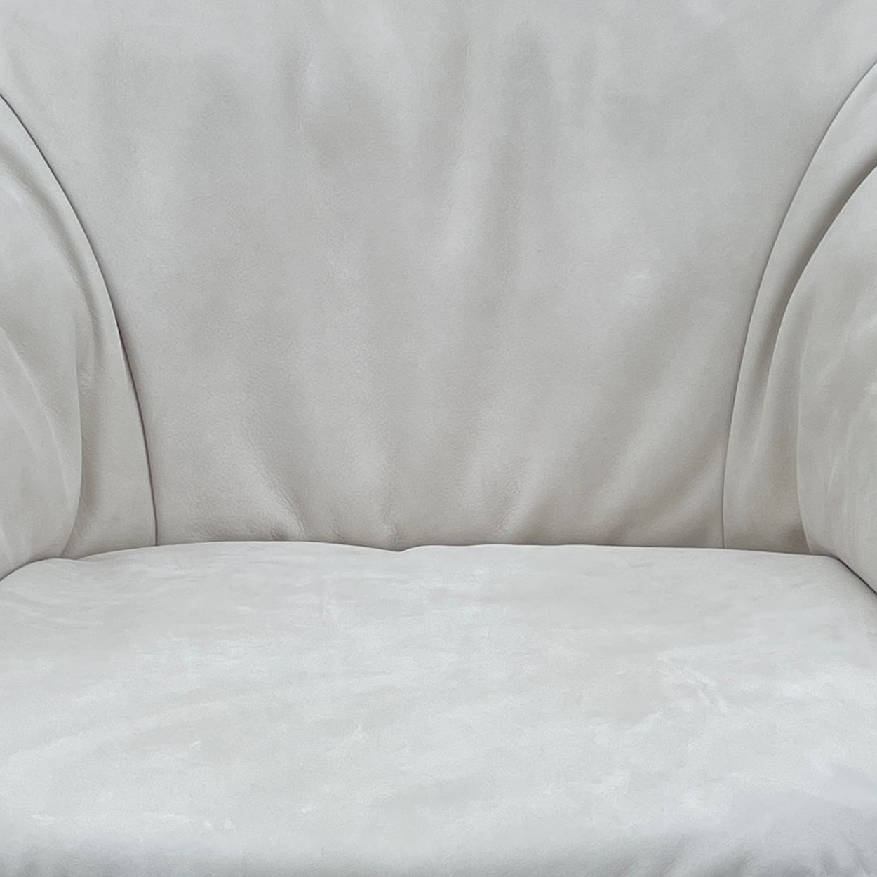 Marie Armchair im Detail: Falten des hellgrauen Leders Cayenne Moon an Lehne und Sitz