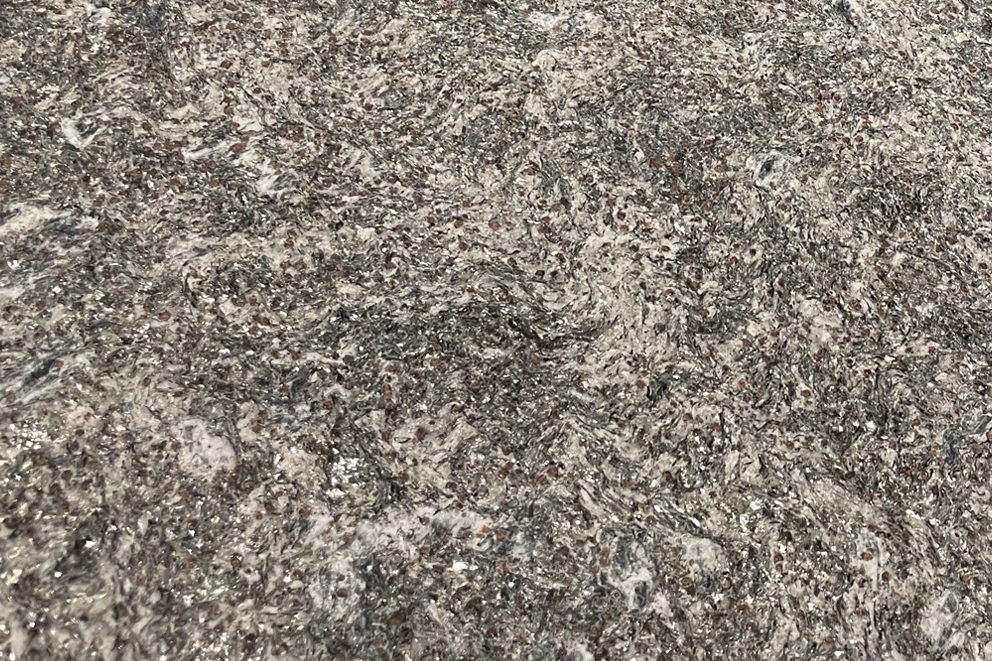 BC 07 Basket Tisch rund im Detail: graue Steinplatte mit hellen Einschlüssen, Nahaufnahme der Oberfläche
