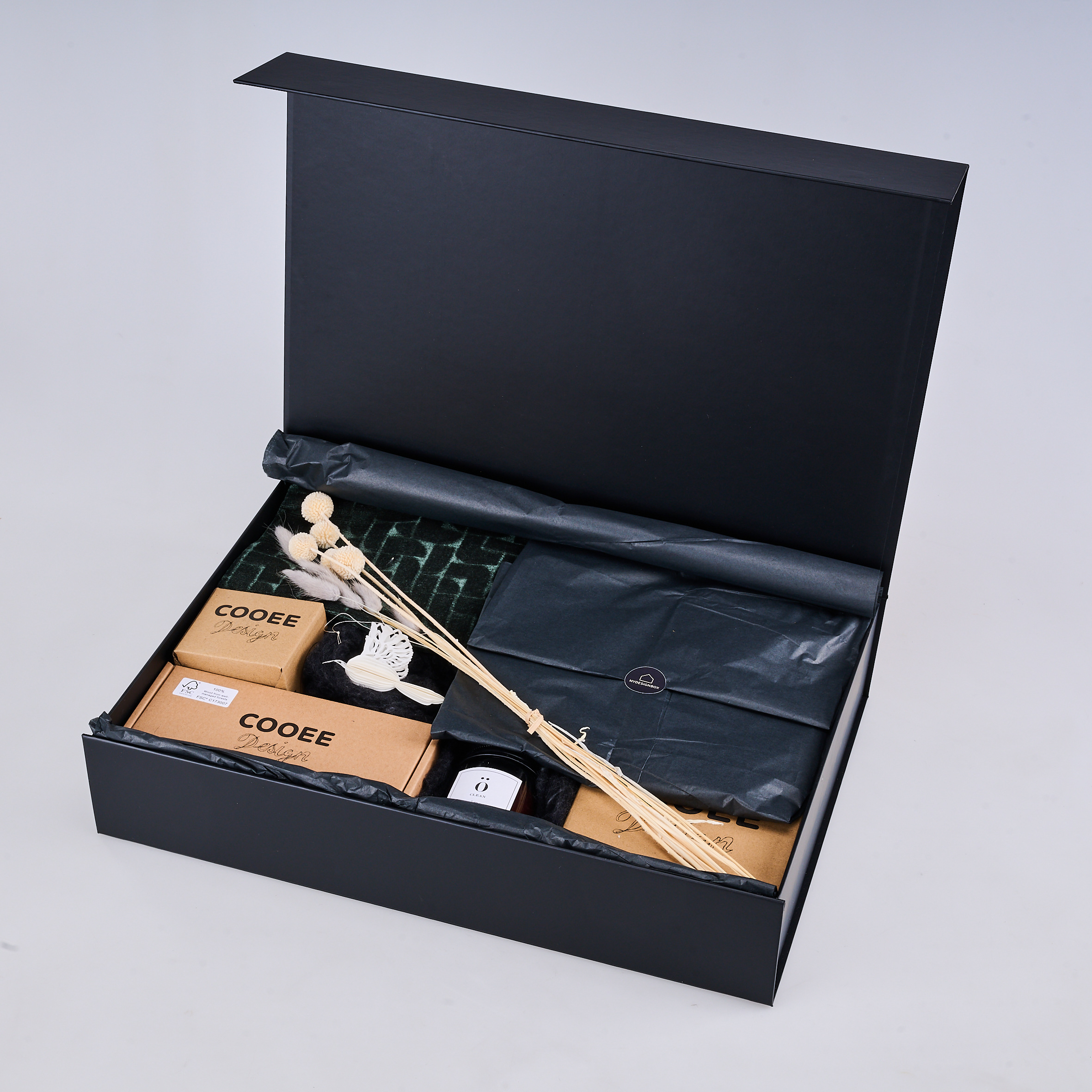 myDesignBox Gold von Melior: geöffnete schwarze Geschenkbox mit Cooee-Accessoires und Trockenblumen