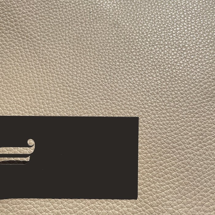Leder Cairo Angora in Beige, Nahaufnahme der genarbten Oberfläche mit schwarzem Etikett
